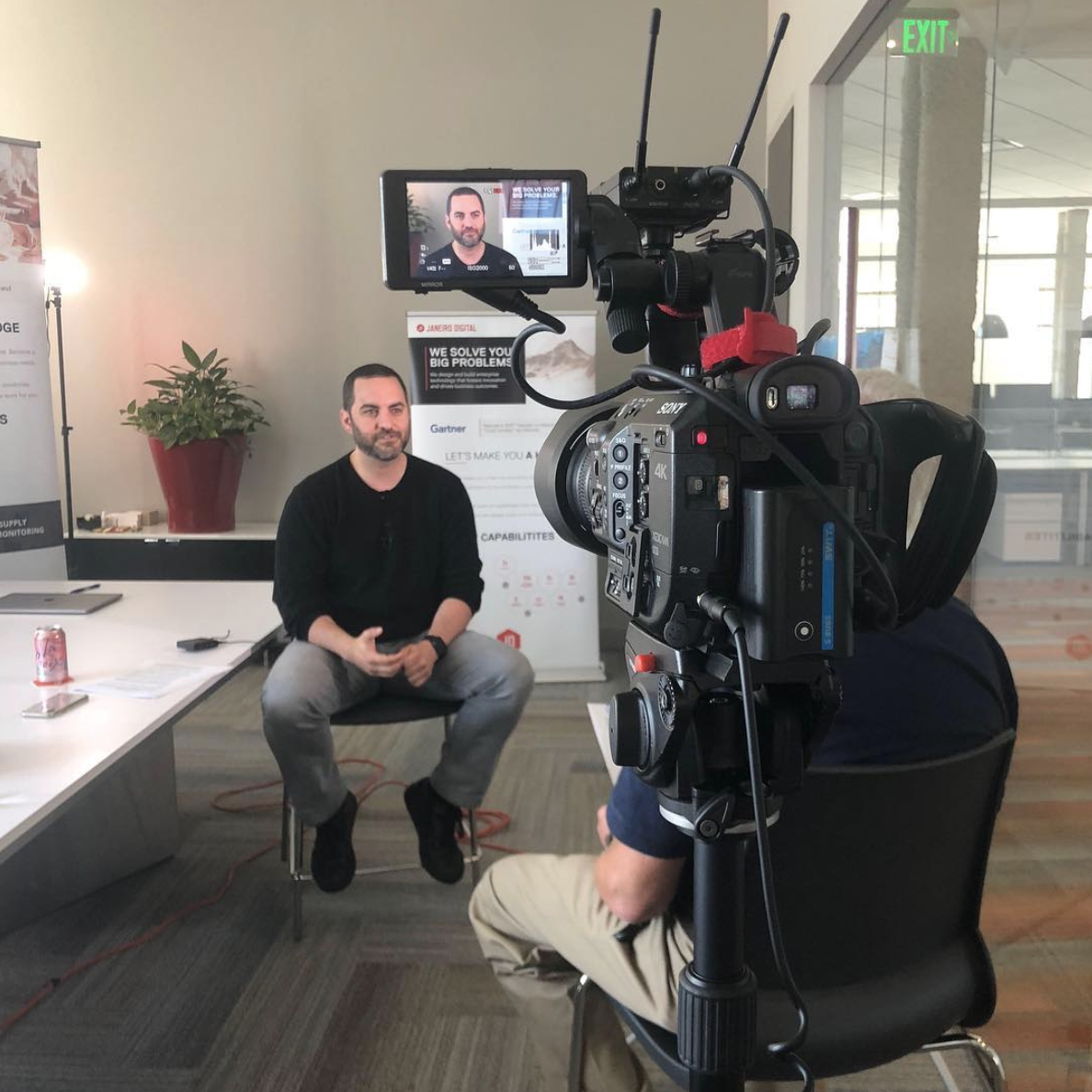 Justin seated for a filmed interview at Janeiro Digital, in front of a Sony cinema camera